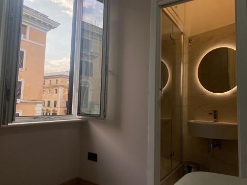 ein Bad mit einem Waschbecken und einem Fenster in der Unterkunft Leonard Vatican House in Rom