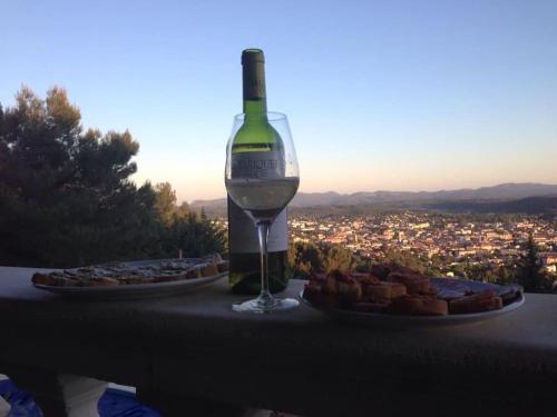 a bottle of wine and a plate of food on a table at Les Amandiers in Draguignan