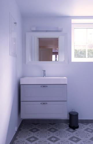 a white bathroom with a sink and a mirror at Studioleilighet i Sandnes sentrum in Sandnes