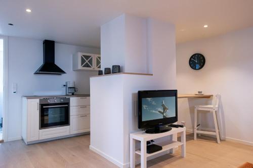 a living room with a tv on a white wall at Koselig studioleilighet i Sandnes sentrum in Sandnes
