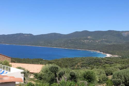 - une vue sur une étendue d'eau avec des montagnes dans l'établissement CHEZ ADRIEN 108-Appartement magnifique vue mer piscine chauffée, à Serra-di-Ferro