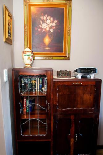 a wooden cabinet with a painting on the wall at aHa Guest House in Sea View