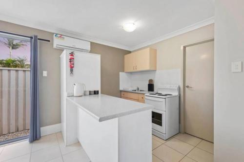 a kitchen with white appliances and a balcony at One bedroom holiday rental in Scarborough in Scarborough