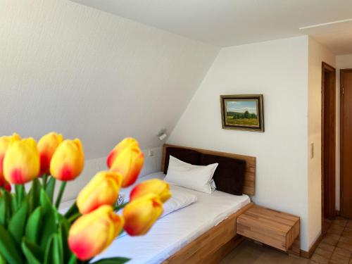 um quarto com uma cama com tulipas amarelas em Haus *Üüs Aran* Wohnung Nr. 3 em Nebel