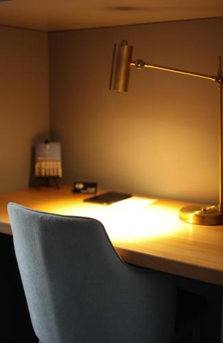 a desk with a chair and a lamp on it at Gruner Hotel in Lviv
