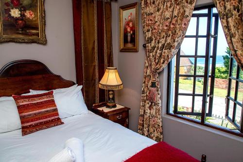 a bedroom with a bed with a lamp and a window at aHa Guest House in Sea View