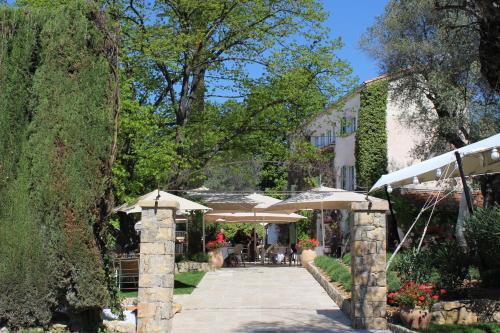 a patio with umbrellas in front of a building at Les chambres d'hôtes de L'Oliveraie in Opio