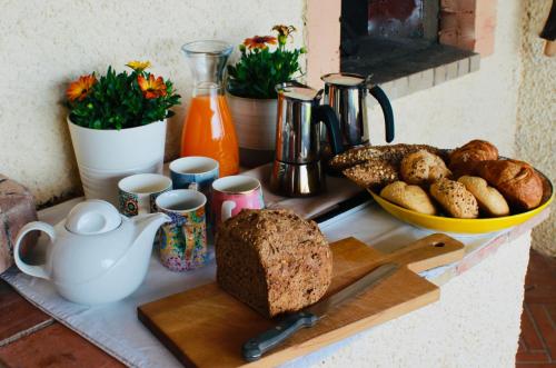 a table with bread and a cutting board with a plate of bread at La Colombaia Amiata in Arcidosso