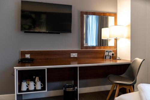 a desk in a hotel room with a flat screen tv at Heeton Concept Hotel - City Centre Liverpool in Liverpool