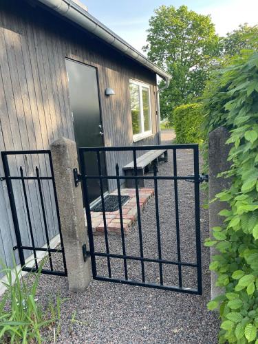 a gate in front of a building with a house at Fiskarstugan i Norra Häljaröd in Norra Häljaröd