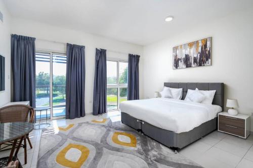 sypialnia z łóżkiem i stołem oraz niektóre okna w obiekcie NEW! Luxurious 3Bedroom Villa with Balcony in RAK w mieście Ras al-Chajma