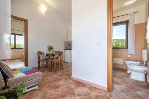 La salle de bains est pourvue d'un canapé, de toilettes et d'une table. dans l'établissement Casa Vacanza Baratz 3, à Alghero