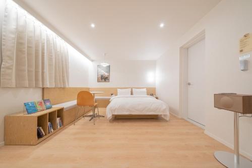 a bedroom with a bed and a desk with a chair at Aank Hotel Cheongju Uam 1st in Cheongju