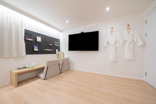 a white room with a tv on a wall at Aank Hotel Cheongju Uam 1st in Cheongju