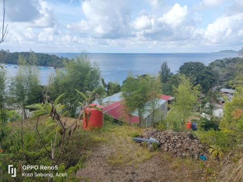 IboihにあるFURQAN GUEST HOUSE Familyの海を背景にした丘の上の家