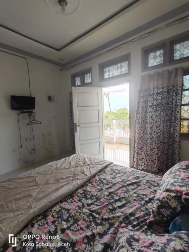 a bedroom with a bed and a window at FURQAN GUEST HOUSE Family in Iboih