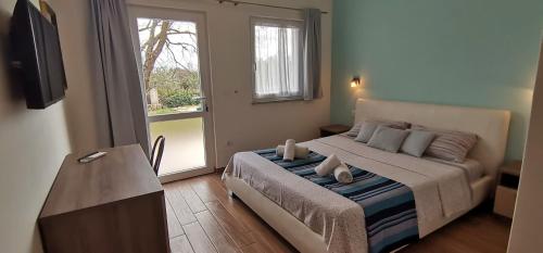 een slaapkamer met een bed, een televisie en een raam bij Holiday House Olly in Rovinj