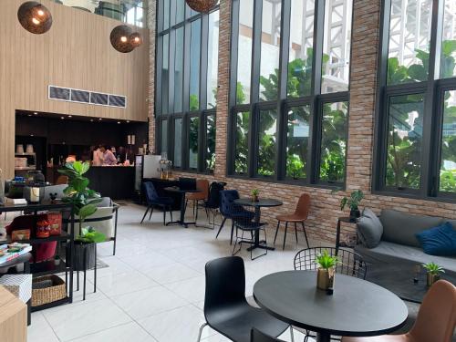 un restaurante con mesas y sillas en un edificio en the Luxe by infinitum suites, en Kuala Lumpur
