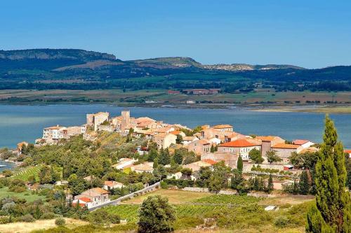 a small town on a hill next to a body of water at Lalagunebages, Panoramic View in Bages