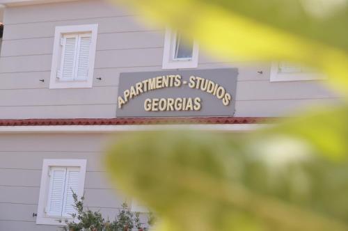 a sign on the side of a white building at Apartments Stoudios Georgias in Arkoudi