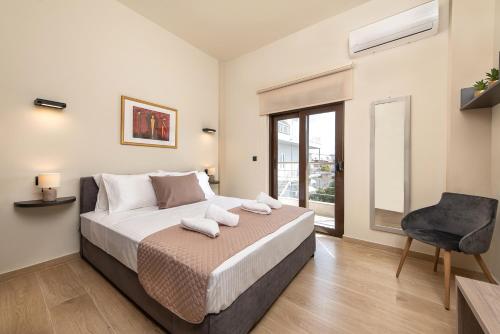 a bedroom with a bed and a chair and a window at Adelais Luxury City Apartment Rhodes in Rhodes Town