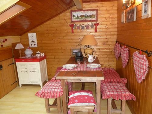 mały pokój ze stołem i krzesłami w kabinie w obiekcie Chalet la Colombière w mieście Sainte-Agnès