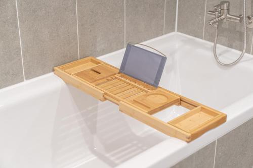 a wooden tray with a laptop sitting on top of a bath tub at Aank Hotel Cheongju Uam 1st in Cheongju