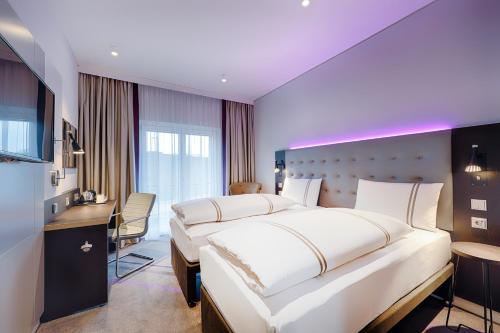um quarto de hotel com uma cama grande e uma secretária em Premier Inn Regensburg City Centre em Regensburg