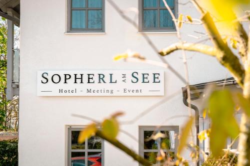 a sign for a hotel meeting event on the side of a building at Sopherl am See - Frühstück auf der Seeterrasse, sehr ruhig und wunderschön am See, 3 Minuten nach Oberpfaffenhofen, viele Radtouren, Restaurants & Cafes in der Umgebung in Weßling