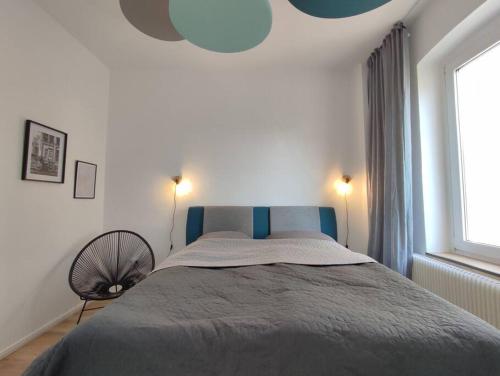 - une chambre avec un lit doté d'une tête de lit bleue et d'une fenêtre dans l'établissement 'BRIGHT 29' schöne, ruhige Innenstadtlage in Bielefeld, 400 m bis Klinikum Mitte, Smart TV, WLAN, à Bielefeld