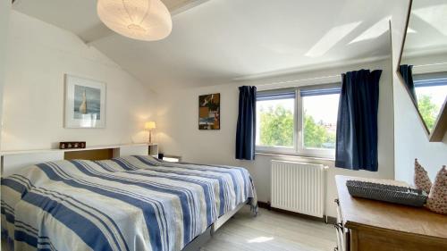 une chambre avec un lit, un bureau et des fenêtres dans l'établissement La Graveline, au Crotoy