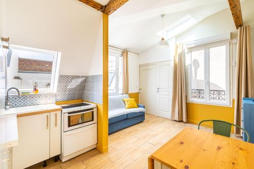 - une petite cuisine avec une table et un canapé dans l'établissement Lovely apartment Paris Saint-Lazare Opéra, à Paris