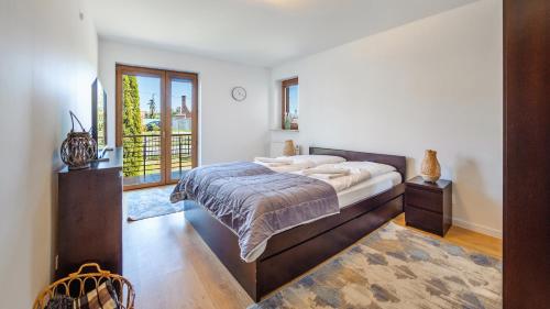 um quarto com uma cama grande e uma janela em Apartamenty Sun & Snow Gdańska II em Krynica Morska