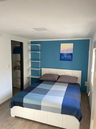 a bedroom with a bed with a blue wall at House Lovre in Zadar