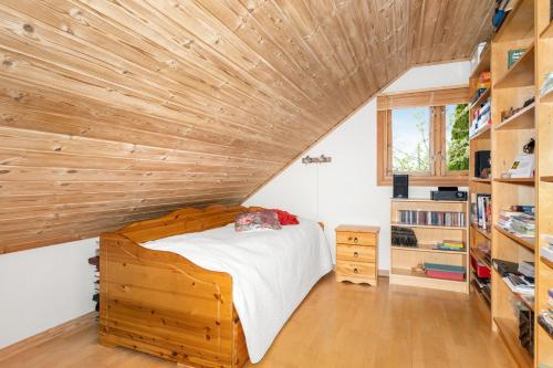 1 dormitorio con techo de madera y 1 cama en una habitación en Enebolig sentralt i Arendal., en Arendal