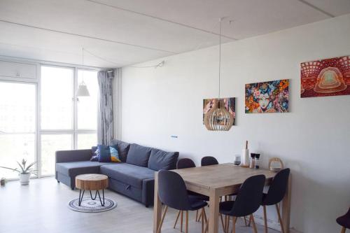 a living room with a blue couch and a table at Nordic design flat including bikes in Copenhagen