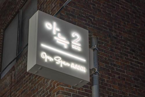 a neon sign on the side of a brick building at The Hyoosik Aank Hotel Cheongju Uam 2nd Branch in Cheongju