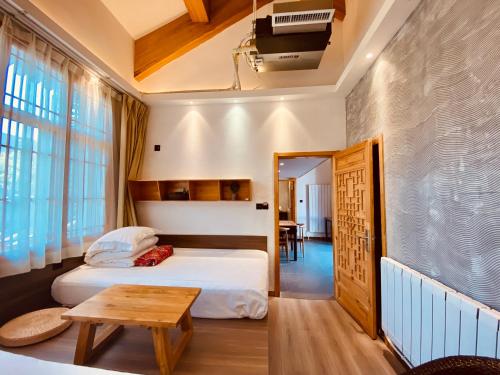 Xi'an Simple Palace في شيان: غرفة نوم بسرير وطاولة في غرفة
