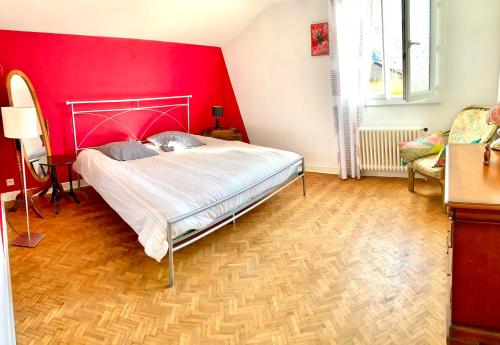 - une chambre avec un mur rouge et un lit dans l'établissement Appartement rénové 80 m2, à Foix