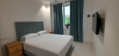 a bedroom with a white bed and a window at Areni Lodge in Areni