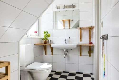 La salle de bains est pourvue de toilettes et d'un lavabo. dans l'établissement Egen ovanvåning i charmig villa nära havet, à Ystad