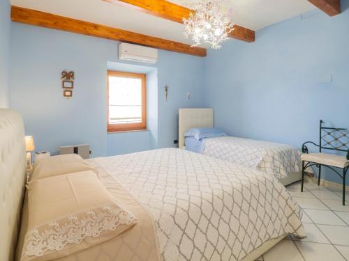 Habitación azul con 2 camas y lámpara de araña. en Casa nel Blu, en Portoscuso