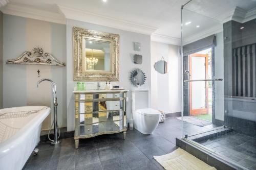 a bathroom with a tub and a sink and a shower at Holland House B&B in Durban