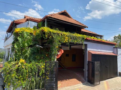 a house covered in flowers and vines at Coorg North Breeze Homestay in Madikeri