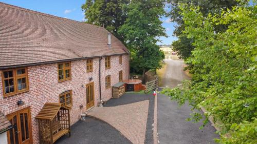 uma vista superior de uma casa de tijolos com uma entrada em The Roost Group - 29 Guests - Two Luxury Barns em Gravesend