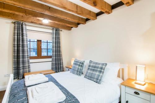 um quarto com uma cama branca e uma janela em The Roost Group - 29 Guests - Two Luxury Barns em Gravesend