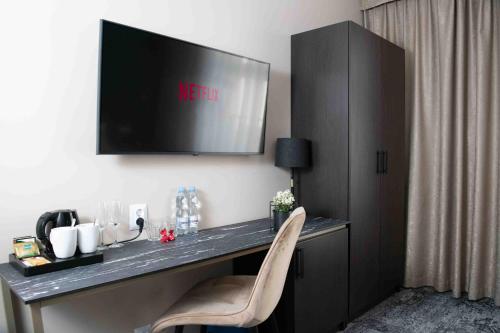 escritorio con TV en la pared y silla en 4Wings Apartments, en Cracovia