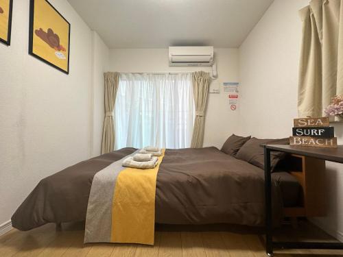 a small bedroom with a bed and a window at nestay inn tokyo kagurazaka in Tokyo