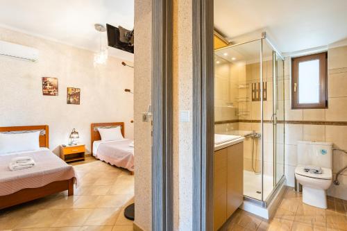 a bathroom with a bed a toilet and a shower at Entheon Olive Villas - Poolside Retreats in Marathopoli