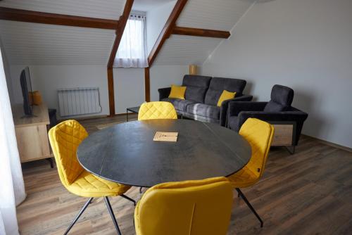 une salle à manger avec une table, des chaises et un canapé dans l'établissement L'Appart de La Grande Boutique du Vin Beaune, à Beaune